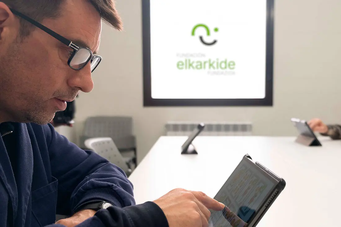 Persona usuaria de los servicios de Elkarkide haciendo ejercicios cognitivos en tablet